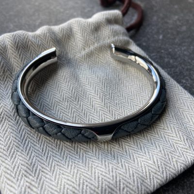 Gray leather braided cuff bracelet in polished stainless steel.