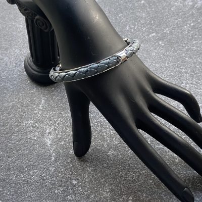 Gray leather braided cuff bracelet in polished stainless steel.