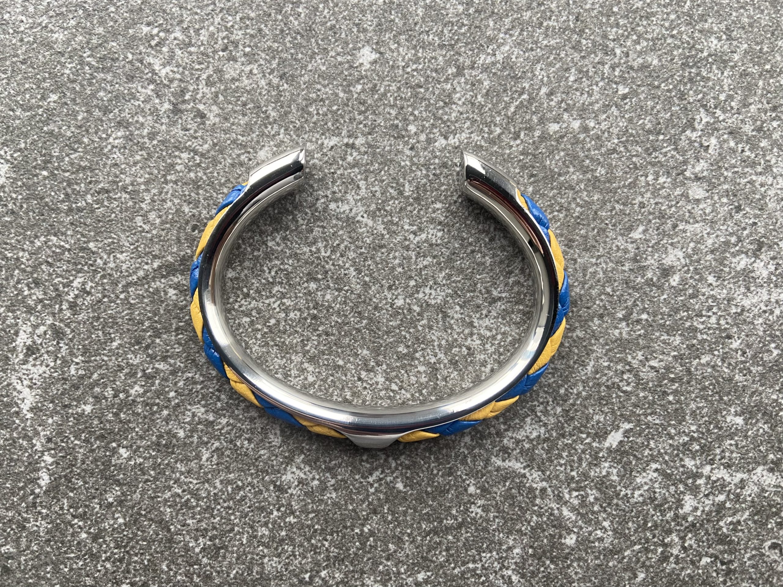Yellow and blue spiral braided leather cuff bracelet with folded edges, stainless steel setting.