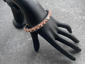 Tan and ivory braided leather cuff bracelet in polished stainless steel.