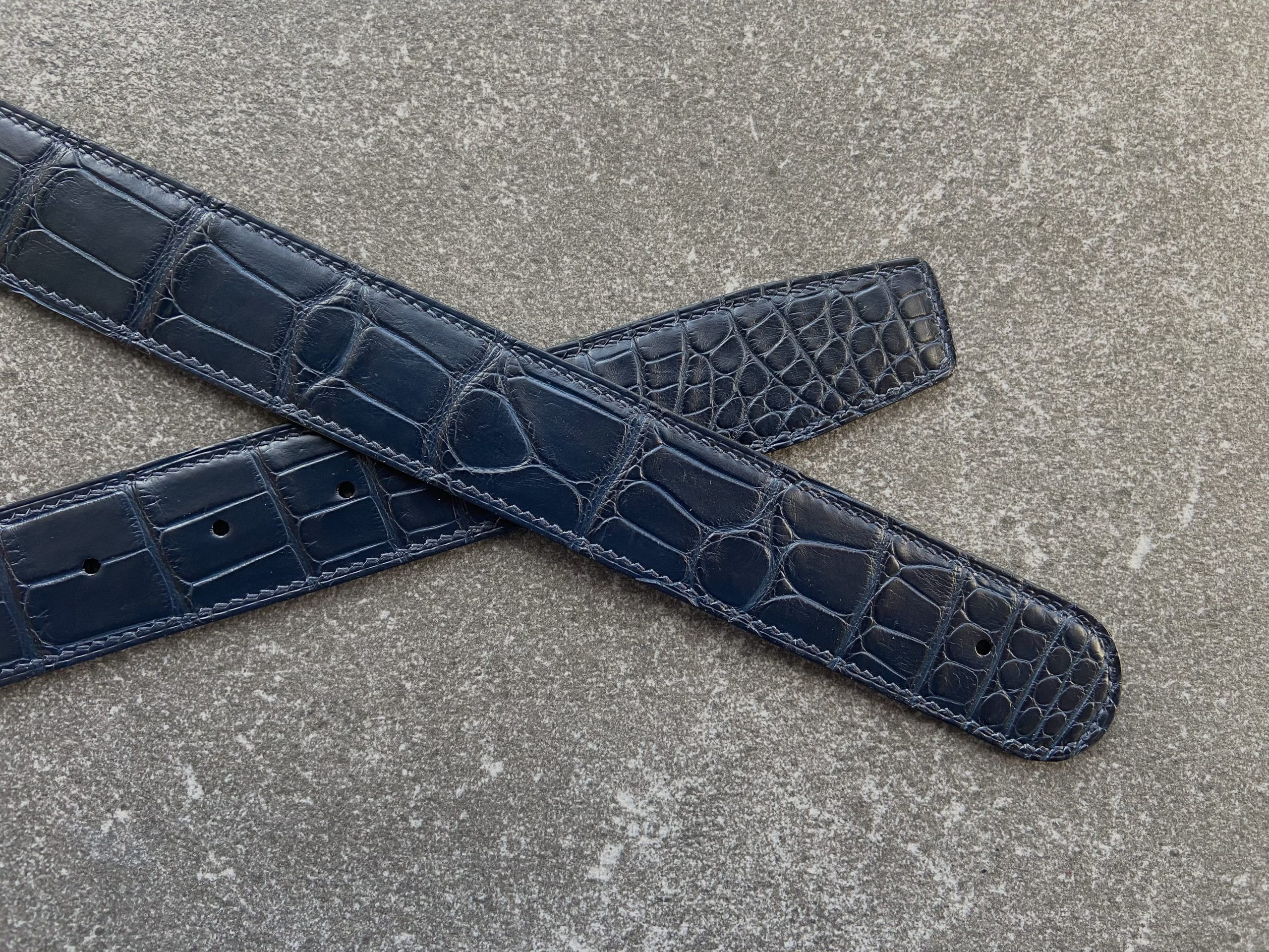 A pair of custom alligator belts crafted to fit customer’s buckes