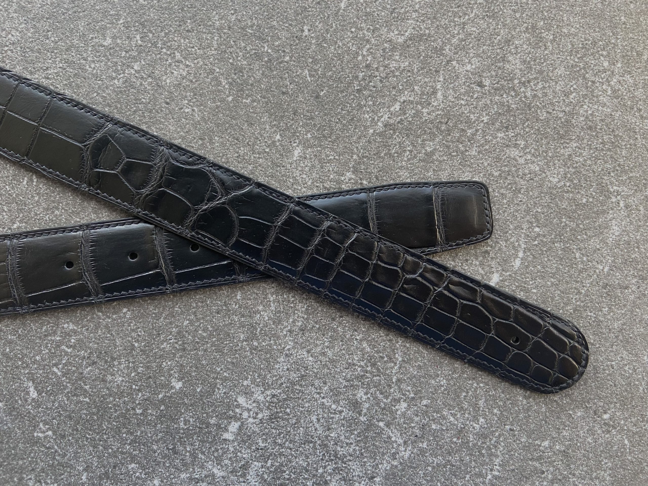 A pair of custom alligator belts crafted to fit customer’s buckes