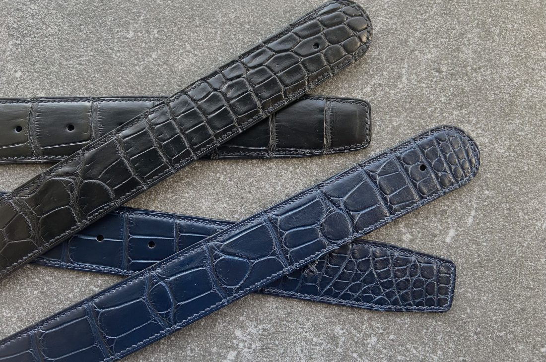 A pair of custom alligator belts crafted to fit customer’s buckes