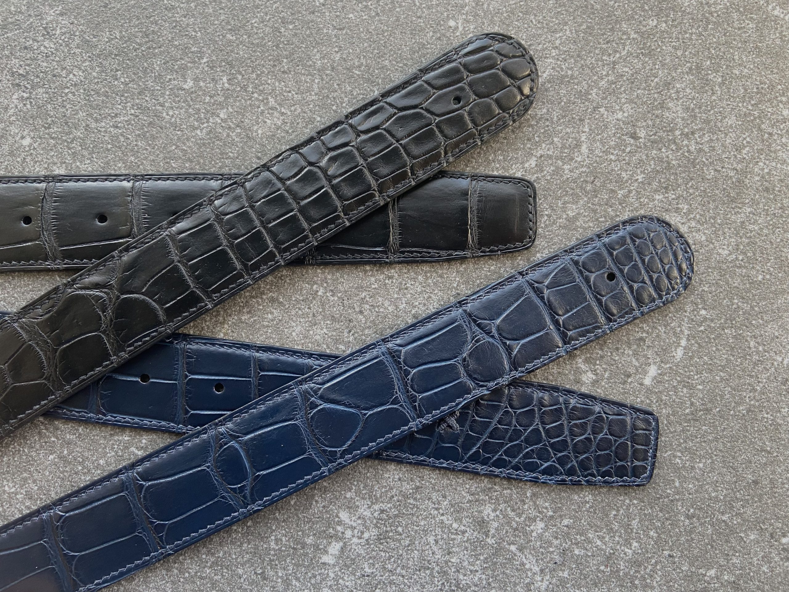 A pair of custom alligator belts crafted to fit customer’s buckes