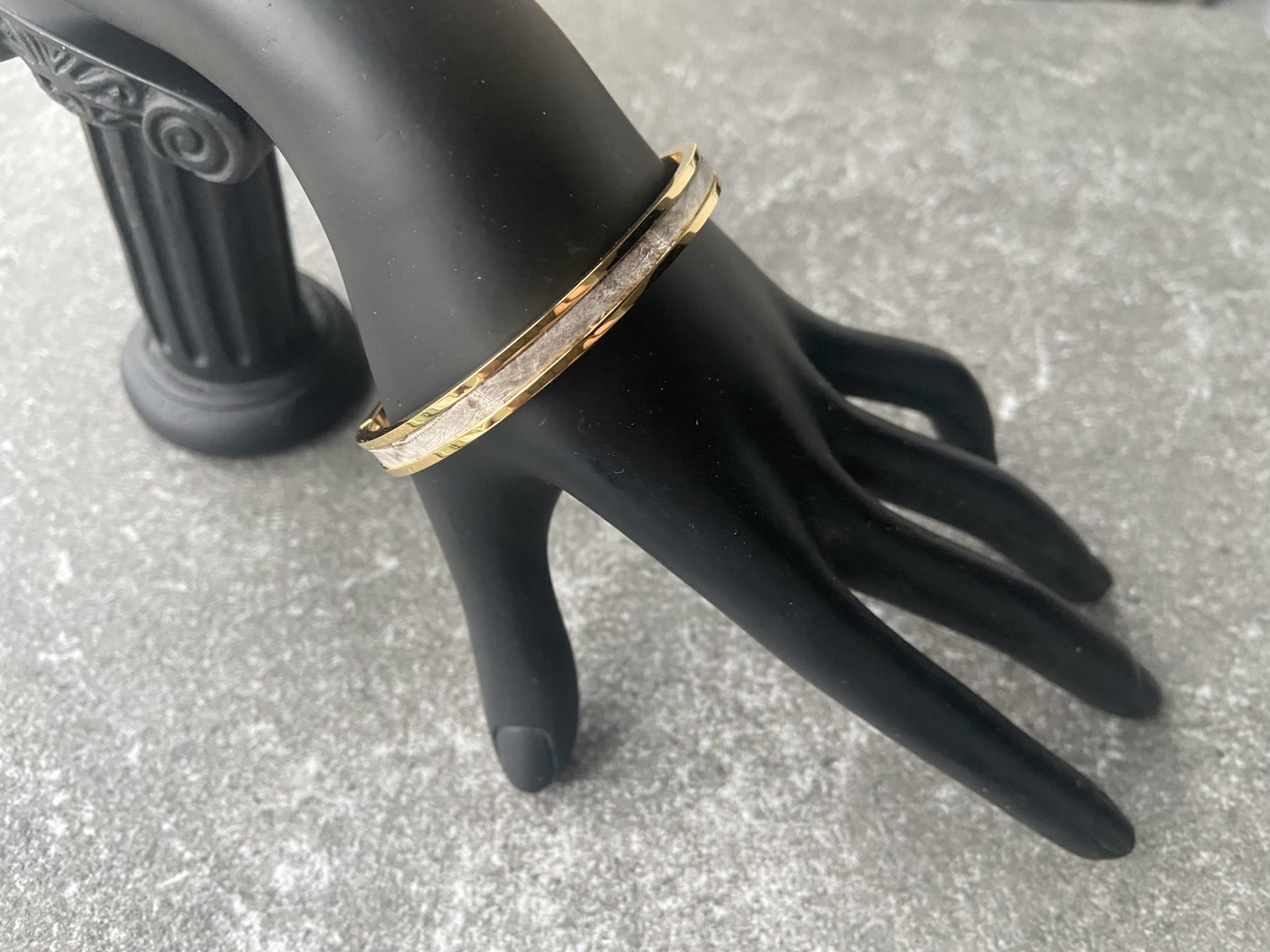Gold-plated stainless steel clic bracelet with Himalaya leather inlay on mannequin hand