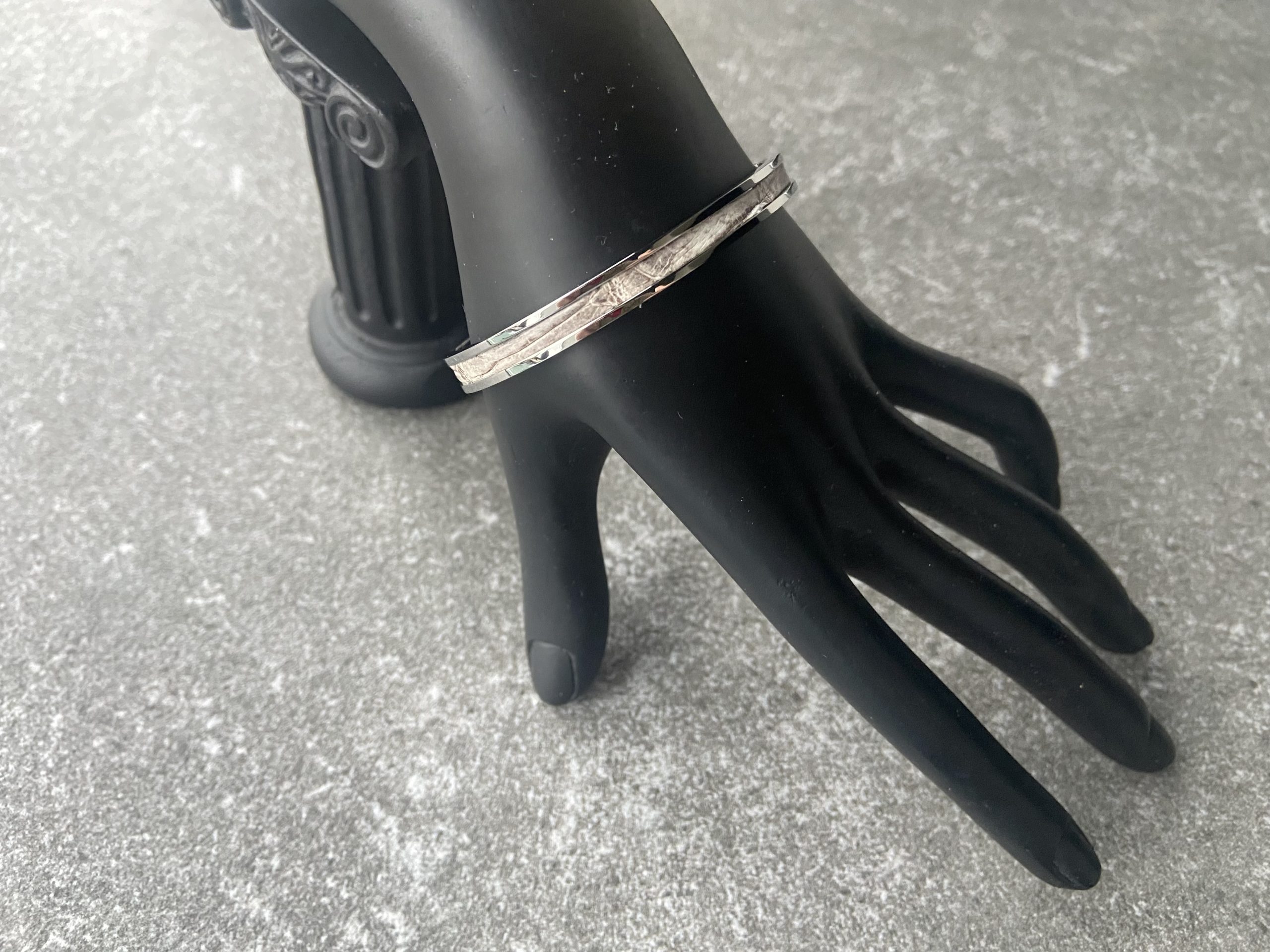 Stainless steel clic bracelet with Himalaya leather inlay on a black display hand