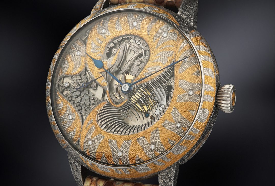 A close-up of a handcrafted watch with a silver and gold python design wrapping around the dial, showcasing the intricate details of the engraving and a visible watch mechanism, complemented by a python skin strap.