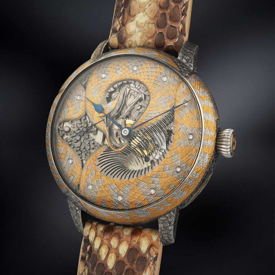 A close-up of a handcrafted watch with a silver and gold python design wrapping around the dial, showcasing the intricate details of the engraving and a visible watch mechanism, complemented by a python skin strap.