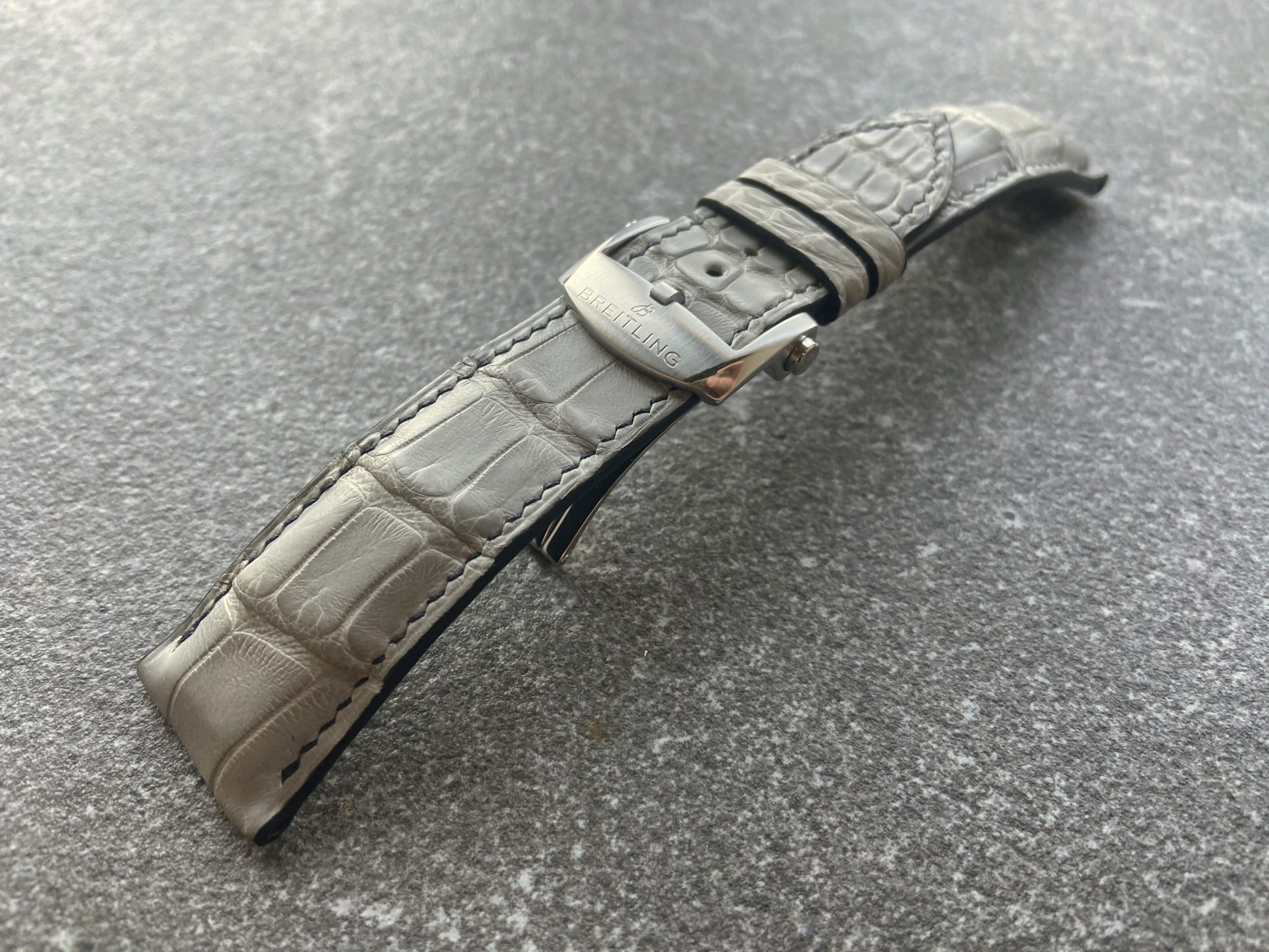Curved grey alligator strap with hand stitching and original Breitling clasp