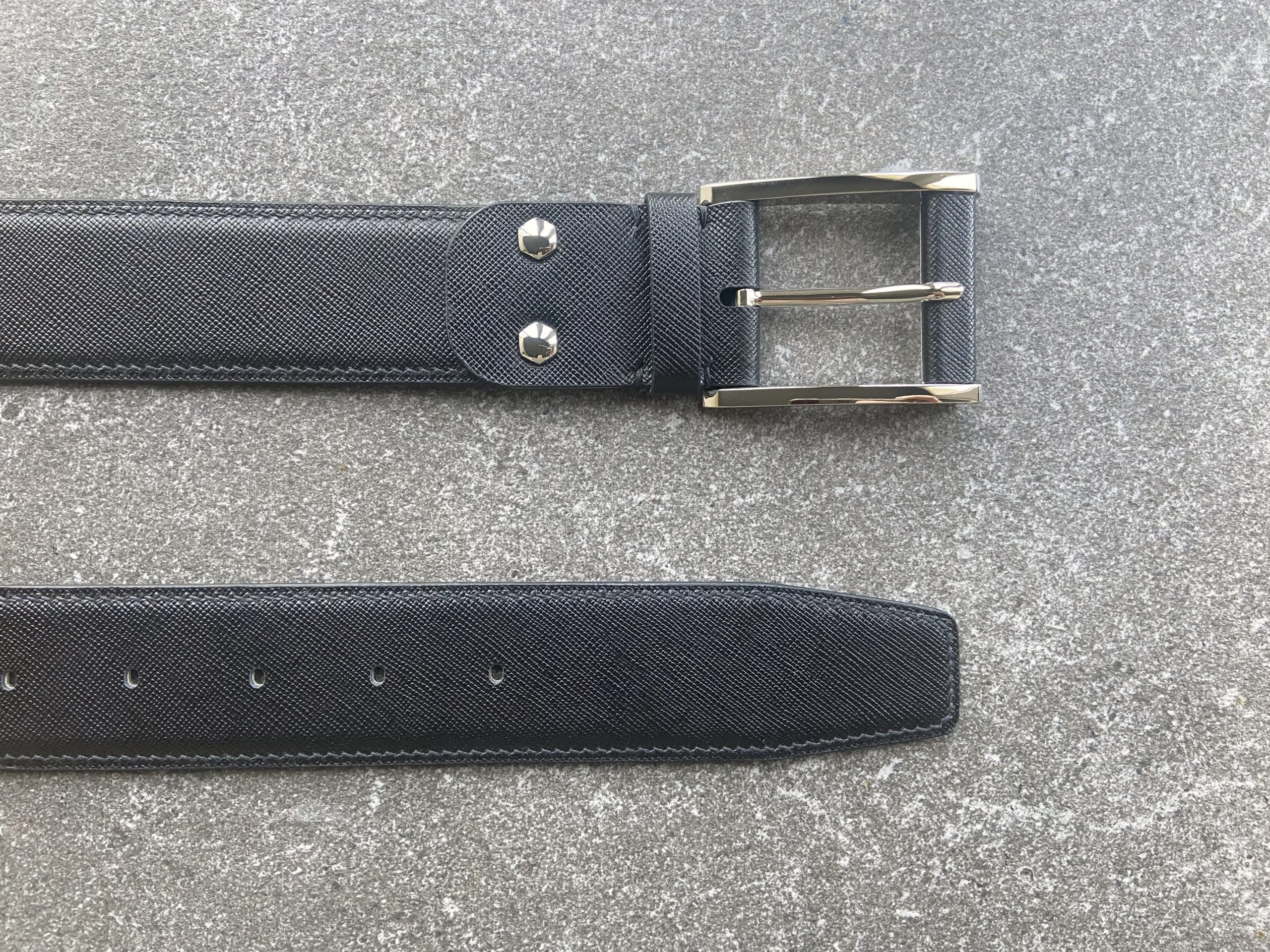 Custom black Saffiano leather belt shown flat with polished brass buckle