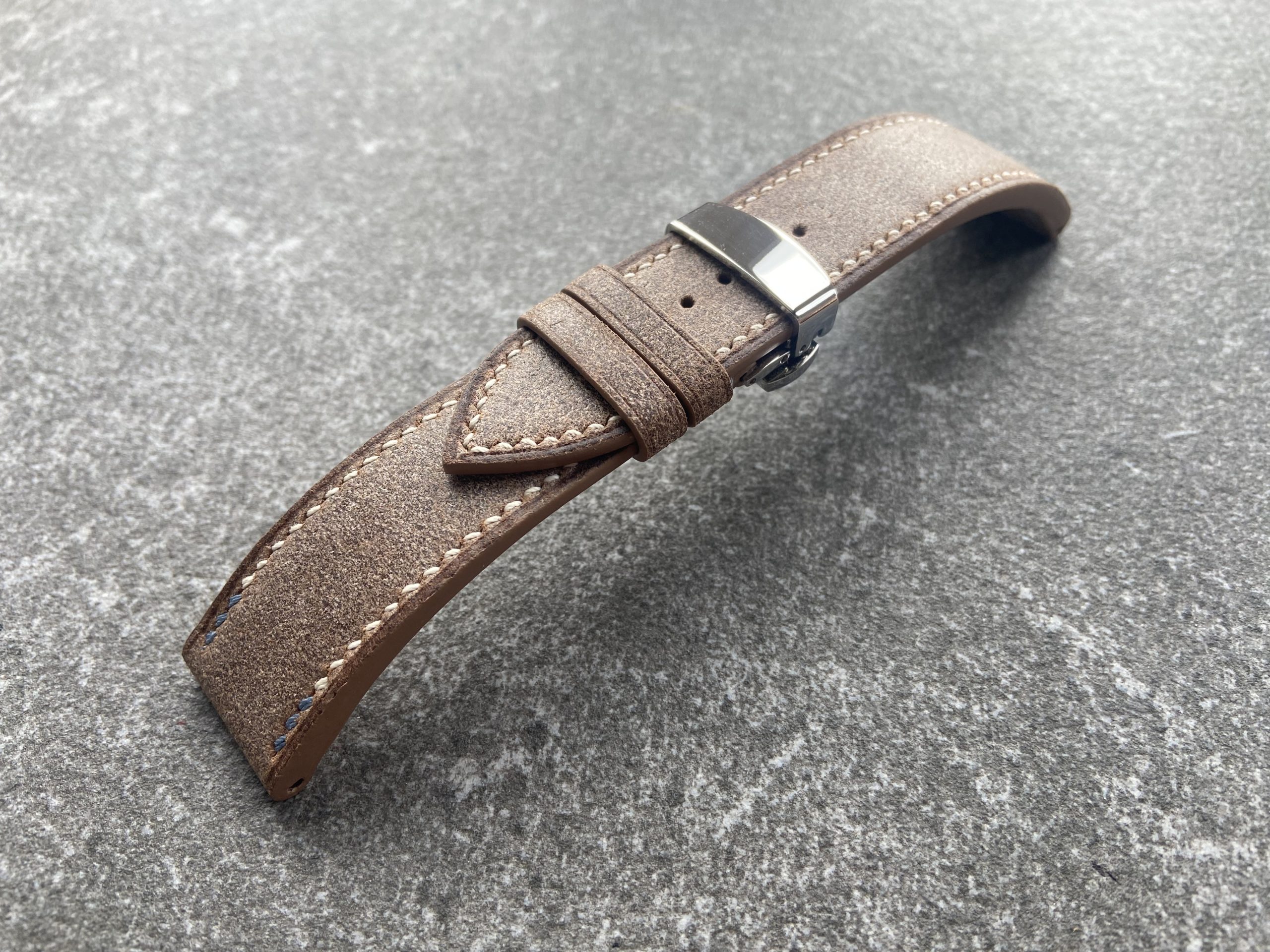 vintage leather watch strap with beige stitching and brushed texture