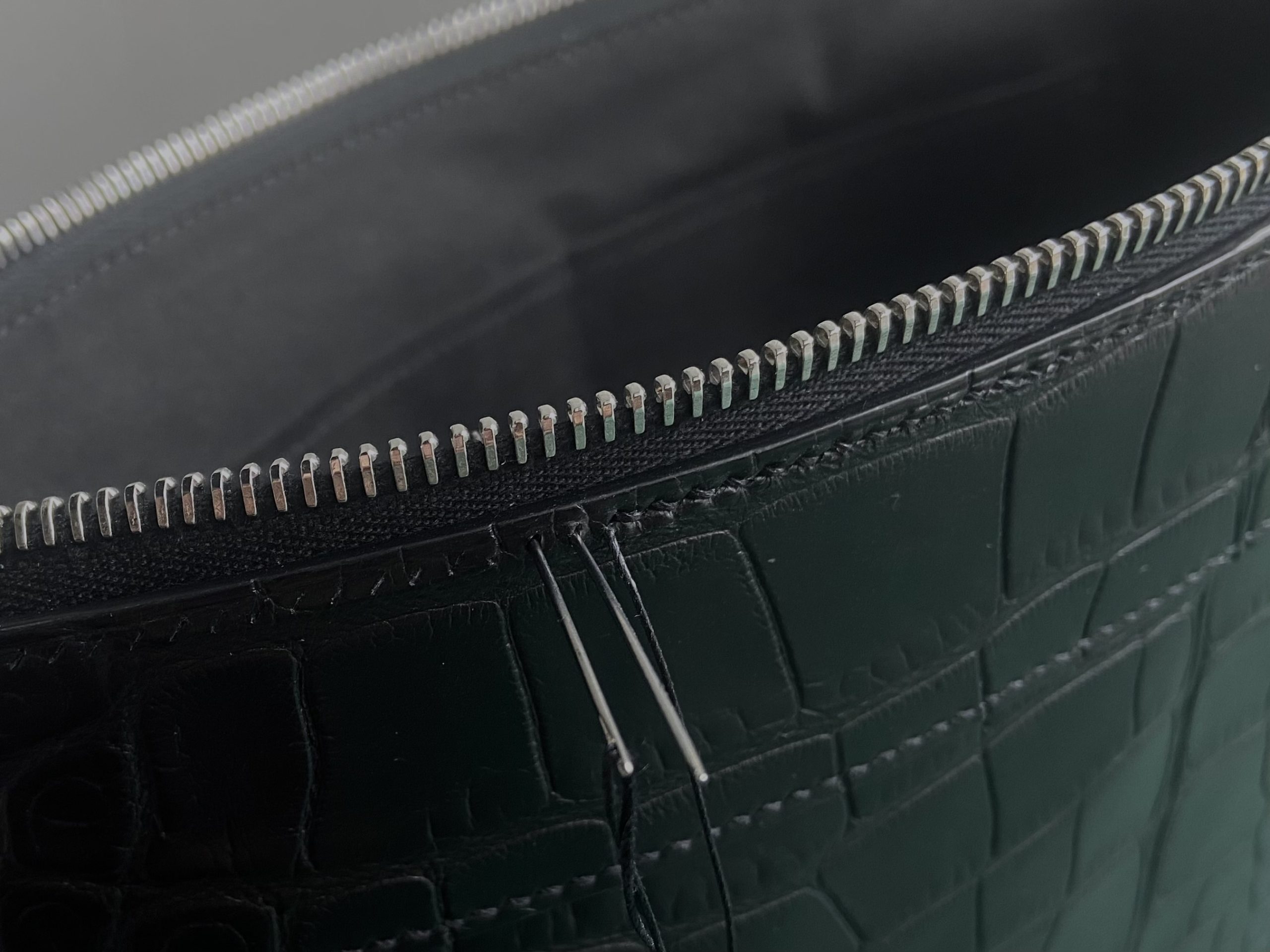 Close-up of the Pochette Voyage Souple showing saddle stitch and RiRi zipper
