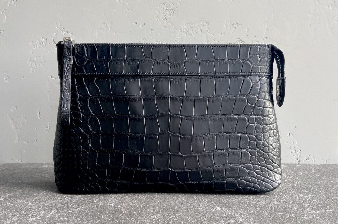 Pochette Voyage Souple in black alligator leather, handcrafted with saddle stitching and NFC tag