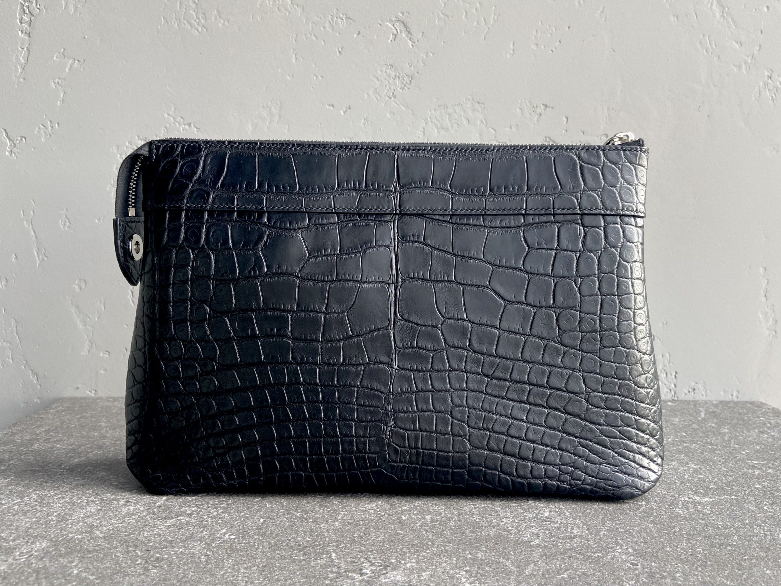 Back view of the Pochette Voyage Souple in black alligator leather