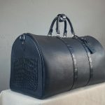 Side view of the bespoke travel bag in black calfskin and matte alligator leather