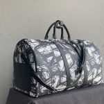 Bespoke duffle bag in brushstroke-patterned leather with black handles and detachable shoulder strap, placed on dark cloth background.