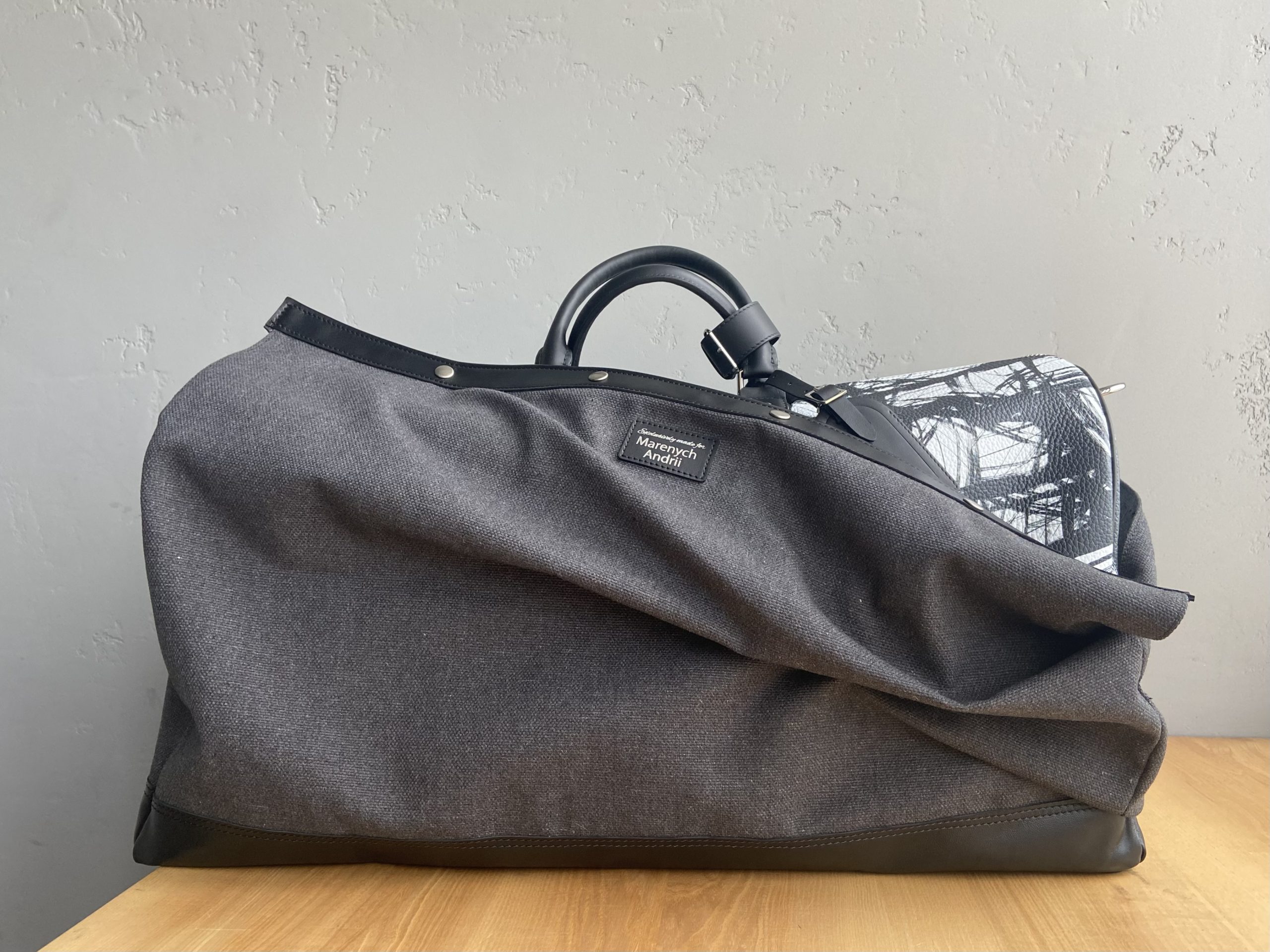 Custom leather travel bag inside its structured protective fabric case
