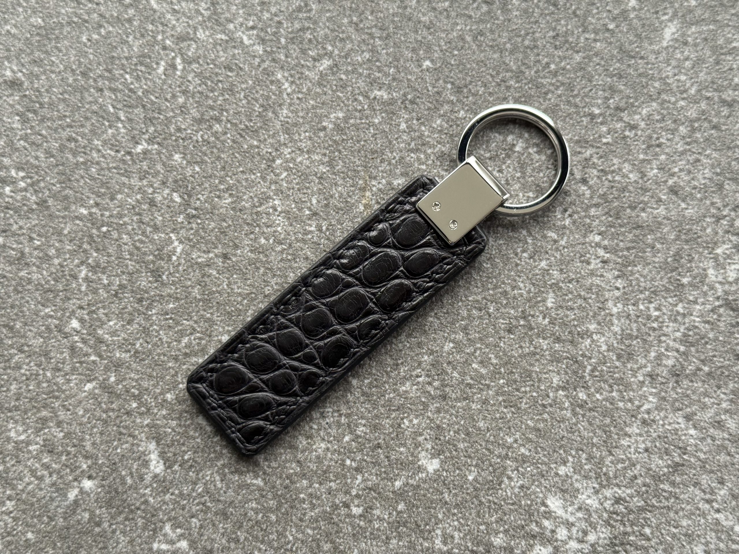 Back side of black structured grain leather key fob with polished 316L stainless steel hardware