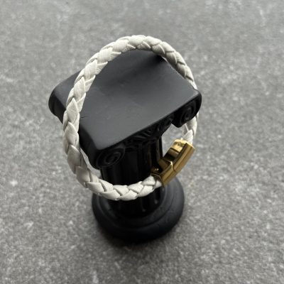 White braided calfskin bracelet displayed on a black column stand