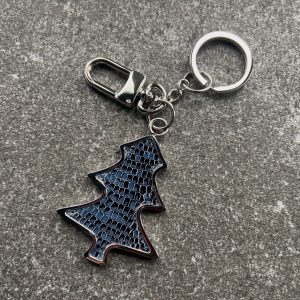 Key chain and bag charm with deep blue scaled texture on a stone surface